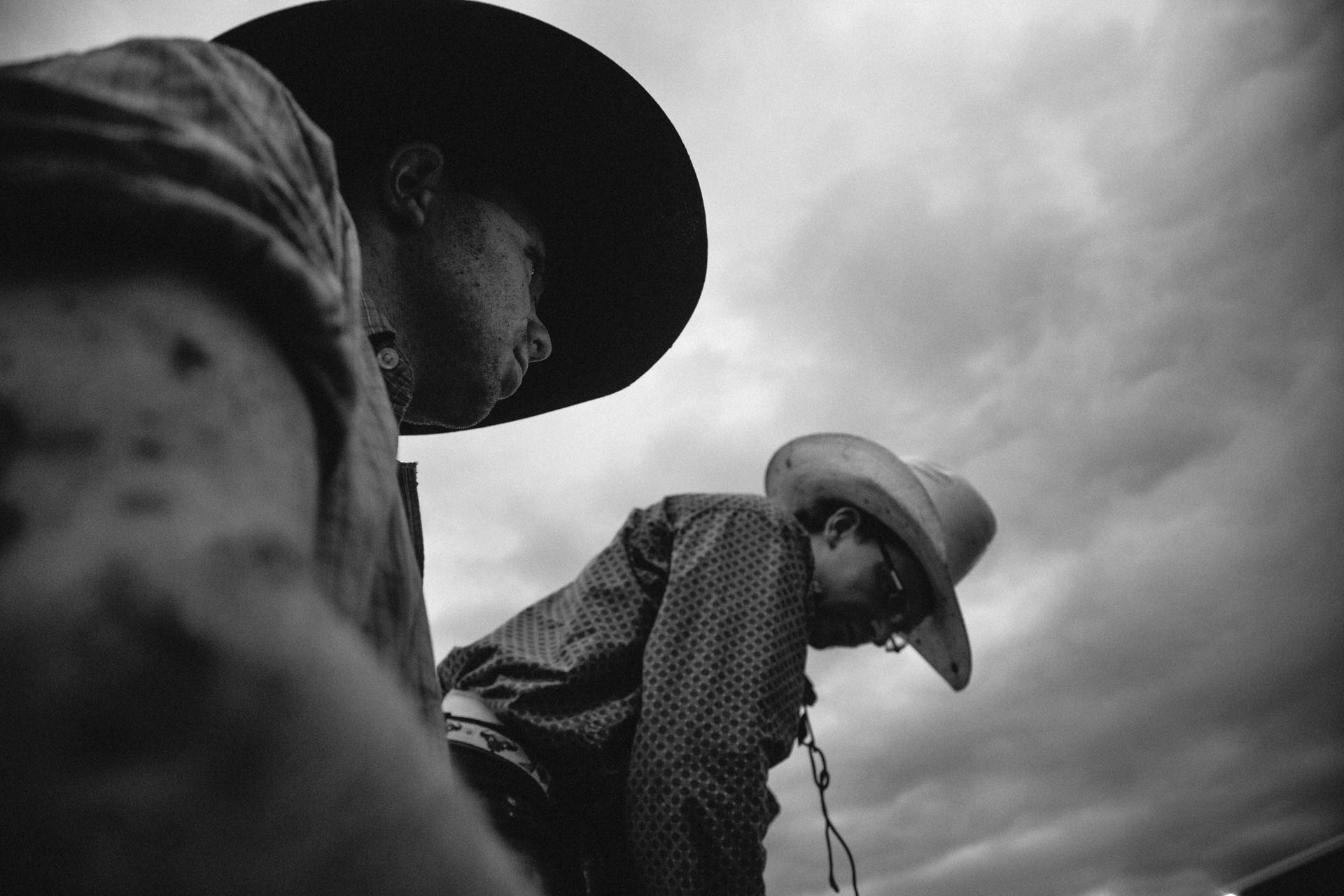 cowboys-covered-in-mud-prepare-for-thebull-dramatic-skies-a5059