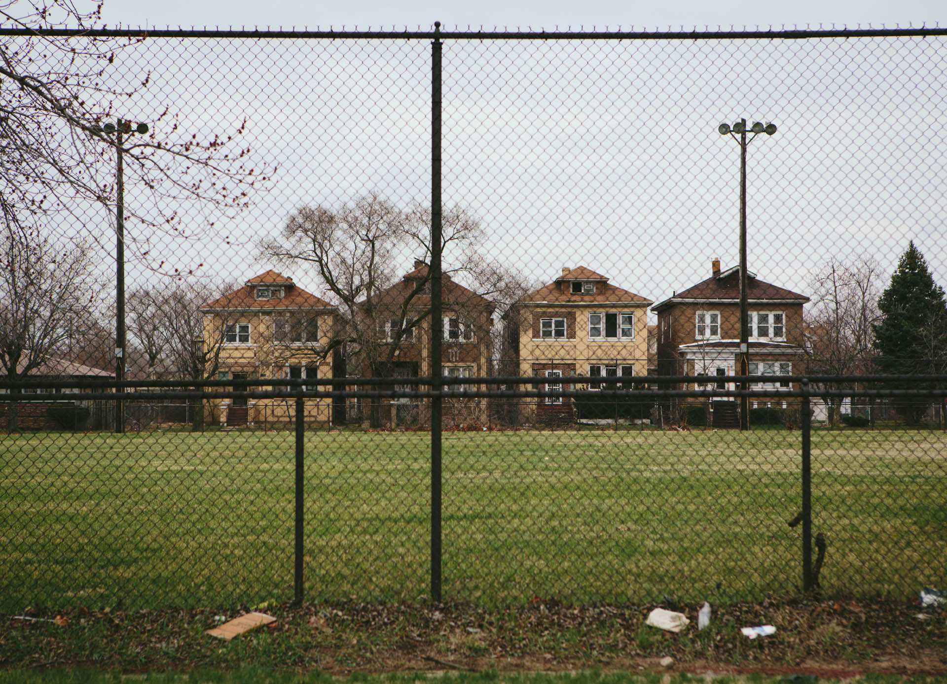 row-of-square-brick-homes-behind-chainlink-fence-gary-in-6058